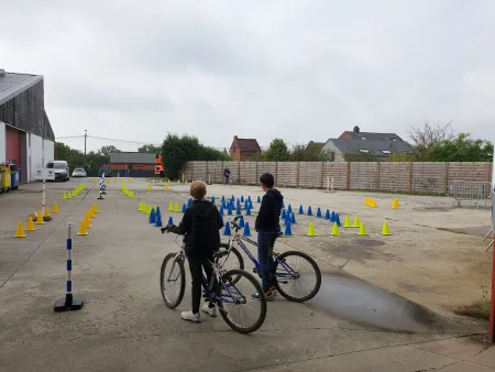 Enfants regardant l'inspecteur de police effectuer le parcours sur la piste d'agilité