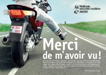 Motard faisant un signe du pied pour dire merci